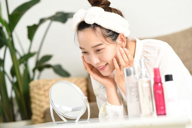 鏡の中の自分をみて喜ぶ女性
